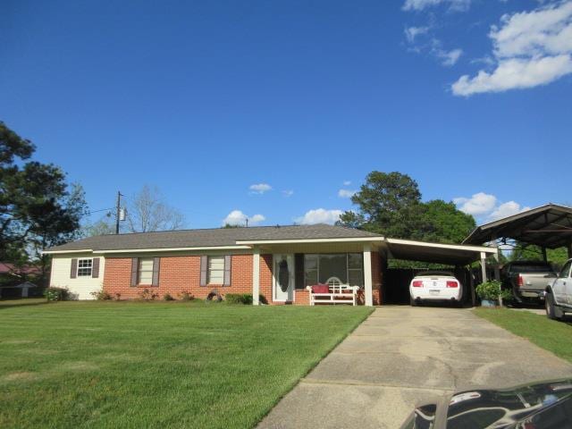 single story home featuring a carport, concrete driveway, brick siding, and a front yard