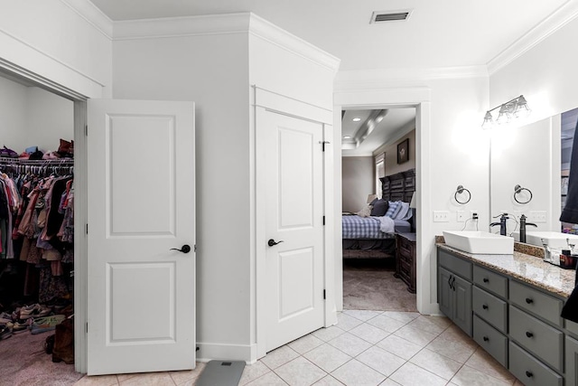 ensuite bathroom featuring visible vents, connected bathroom, tile patterned floors, crown molding, and vanity