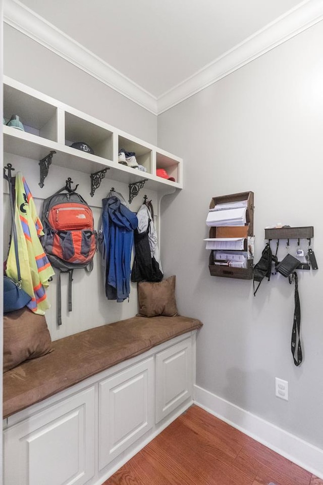 mudroom with ornamental molding, baseboards, and wood finished floors