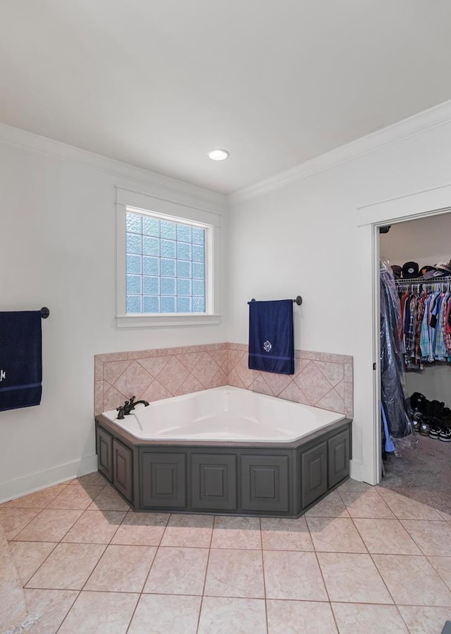 bathroom with tile patterned flooring, crown molding, and a bath