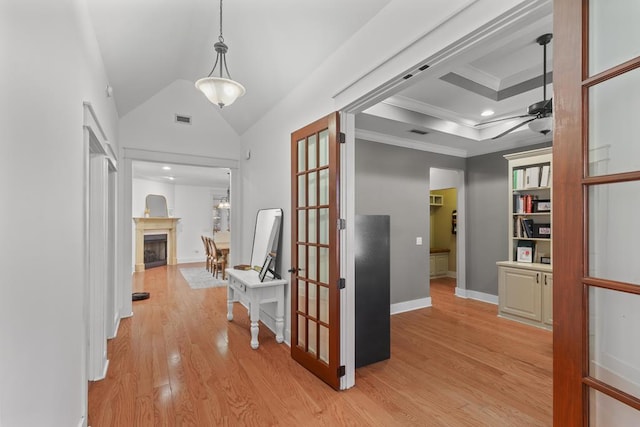 hall with visible vents, lofted ceiling, ornamental molding, french doors, and light wood-style floors