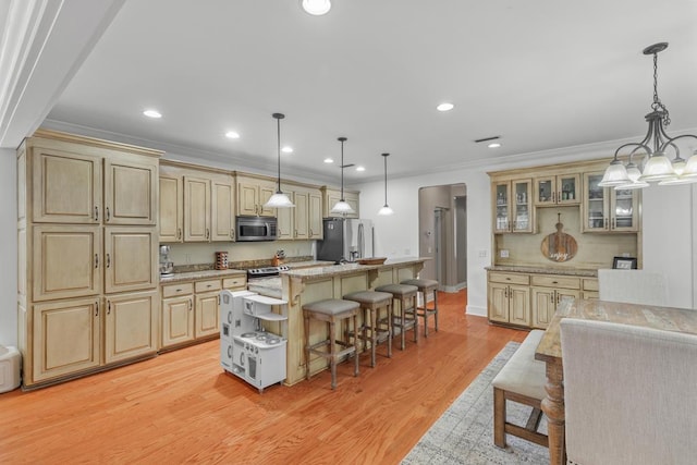 kitchen featuring stainless steel appliances, crown molding, and a breakfast bar area