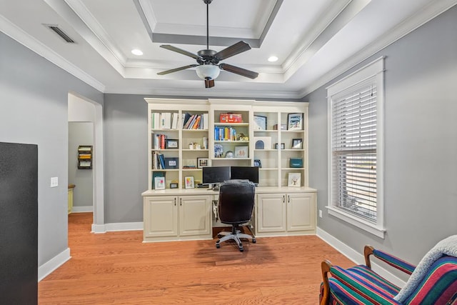 office space featuring light wood-style floors, a tray ceiling, visible vents, and crown molding