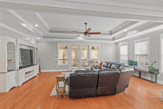 living area with french doors, light wood-type flooring, a raised ceiling, and baseboards