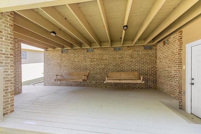 basement featuring wood-type flooring and brick wall