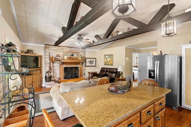 668 Lake Front Dr, Abbeville, AL 36310 - kitchen featuring stainless steel refrigerator with ice dispenser, dark wood-type flooring, light stone counters, brown cabinets, and a fireplace