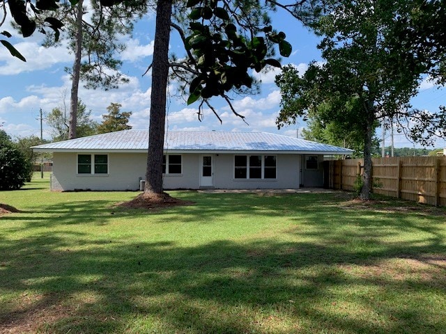 rear view of house featuring a lawn