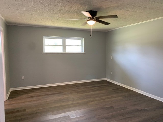 spare room featuring dark hardwood / wood-style flooring, ceiling fan, and crown molding