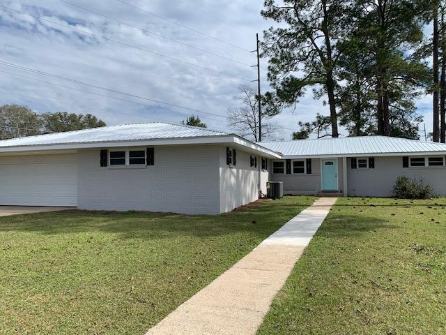 view of front of home with cooling unit and a front lawn