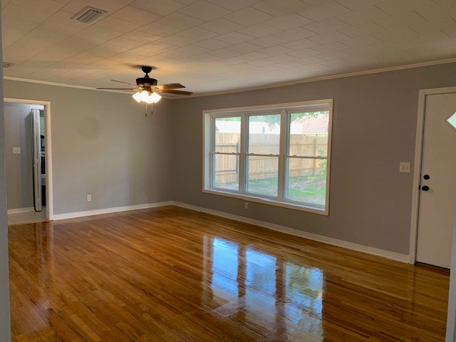 unfurnished living room with ornamental molding, hardwood / wood-style flooring, and ceiling fan