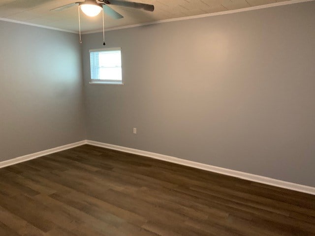 unfurnished room with ceiling fan, crown molding, and dark wood-type flooring