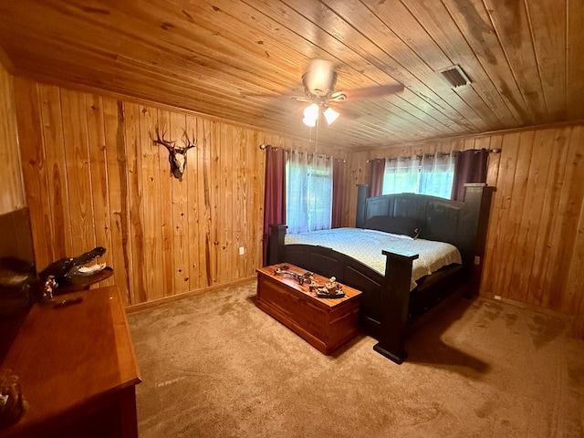 bedroom featuring visible vents, ceiling fan, wood ceiling, wood walls, and carpet flooring