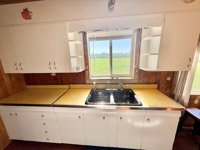 kitchen with light countertops, white cabinetry, a sink, and open shelves