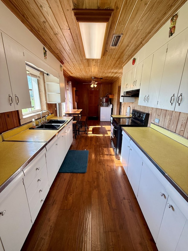 kitchen featuring a sink, white cabinets, visible vents, black range with electric stovetop, and wooden ceiling