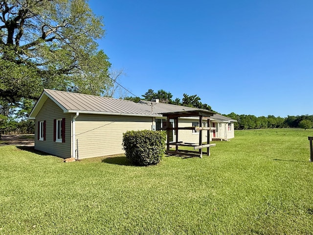view of side of home featuring a yard and metal roof