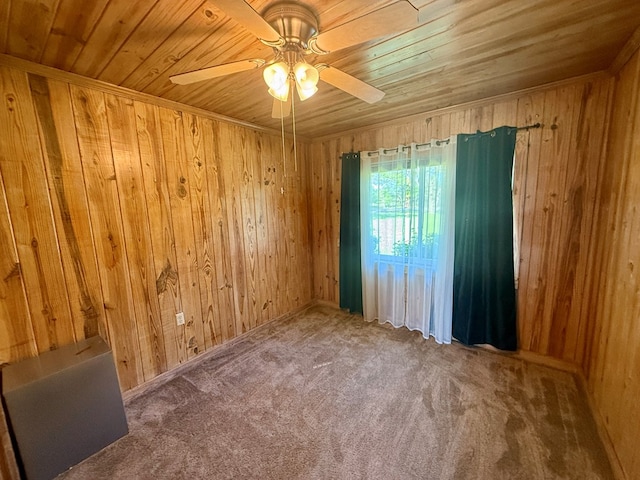 empty room with wood walls, carpet flooring, wooden ceiling, and ceiling fan