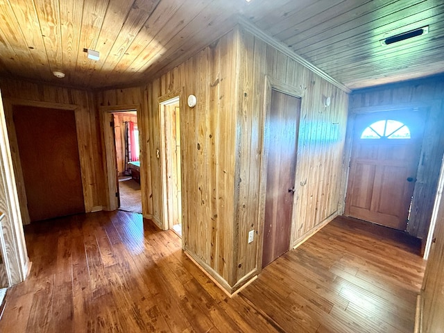 hall featuring wooden walls, hardwood / wood-style floors, and wood ceiling