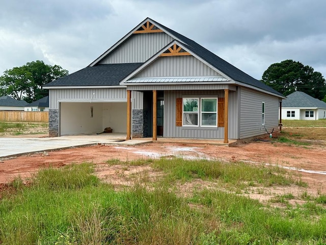 32 Woodham Rd, Ashford, AL 36312 - view of front facade with driveway, board and batten siding, an attached garage, roof with shingles, and covered porch