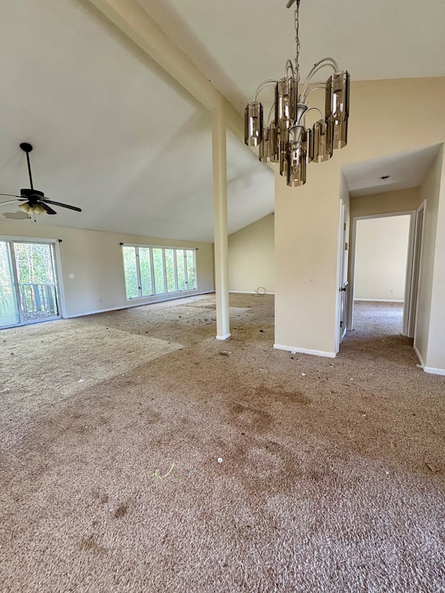 spare room featuring ceiling fan with notable chandelier, carpet floors, and vaulted ceiling