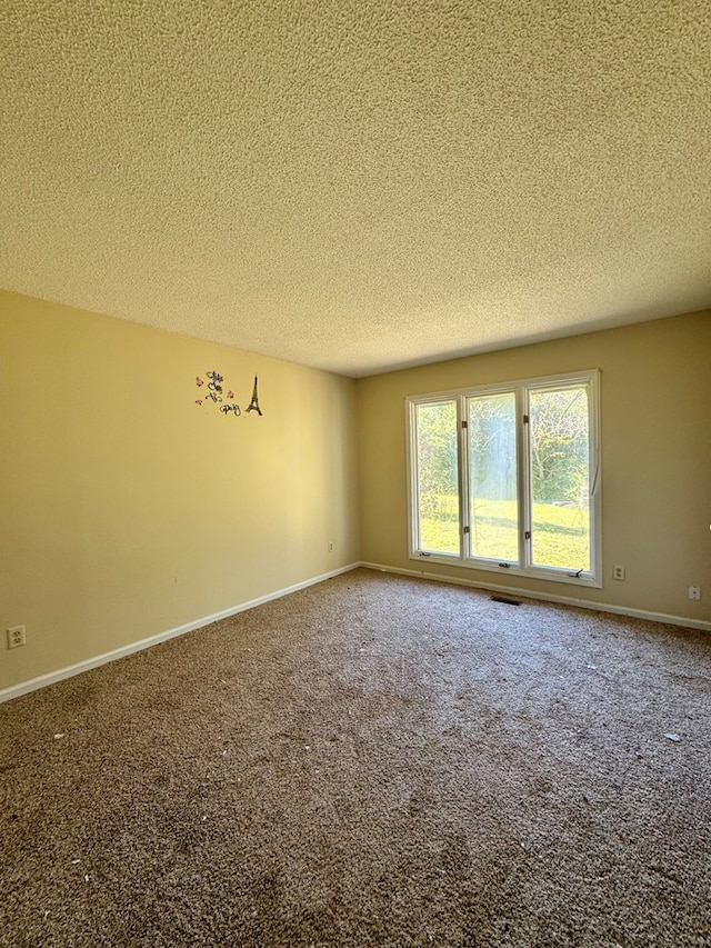 carpeted empty room with a textured ceiling