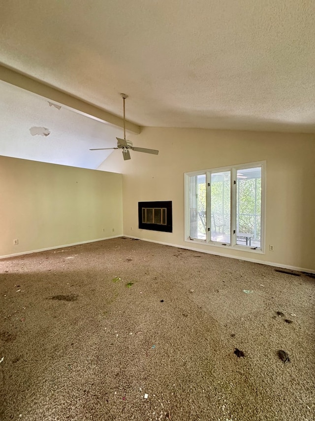 unfurnished living room featuring ceiling fan, carpet, lofted ceiling with beams, and a textured ceiling