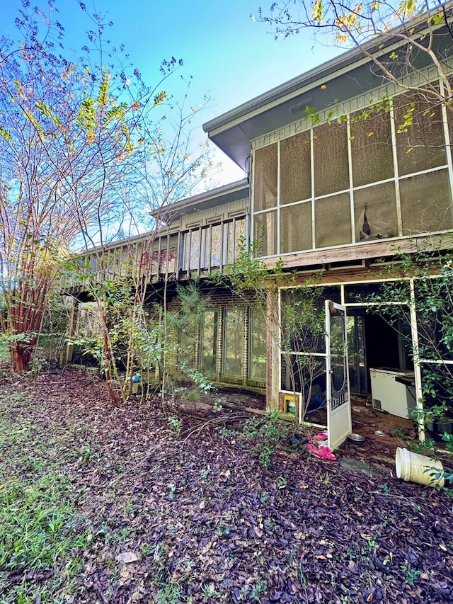 back of property with a sunroom