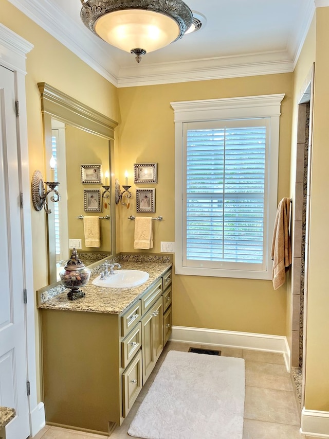 bathroom featuring vanity, visible vents, baseboards, ornamental molding, and tile patterned floors