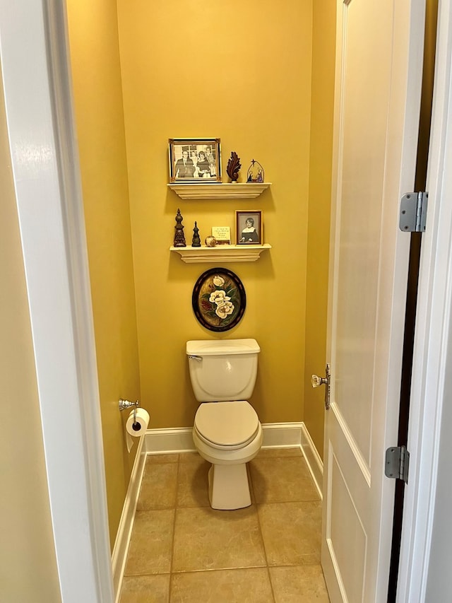 bathroom featuring tile patterned flooring, toilet, and baseboards