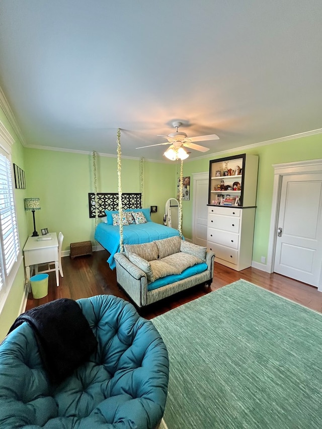 bedroom featuring ornamental molding, a ceiling fan, baseboards, and wood finished floors