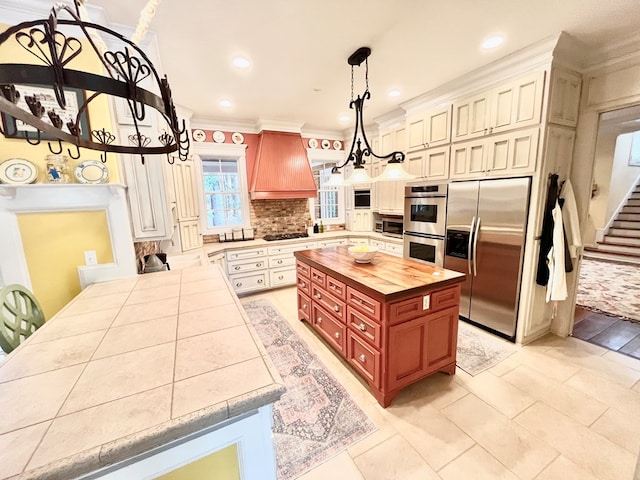 kitchen with stainless steel appliances, butcher block counters, ornamental molding, decorative backsplash, and custom range hood