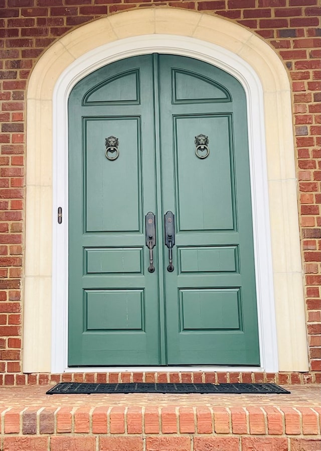 property entrance featuring brick siding