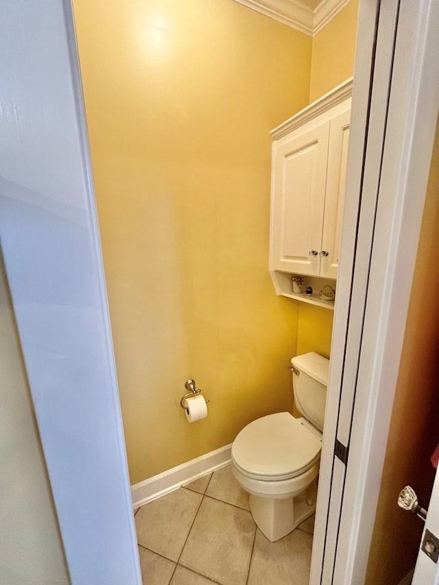 bathroom featuring toilet, tile patterned flooring, baseboards, and crown molding