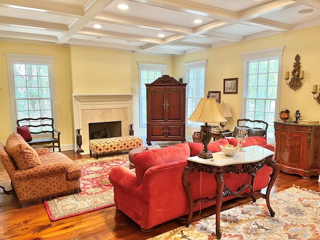 living area with a wealth of natural light, a premium fireplace, coffered ceiling, and wood finished floors