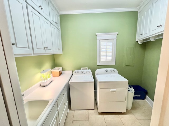 clothes washing area featuring crown molding, washer and dryer, cabinet space, and a sink