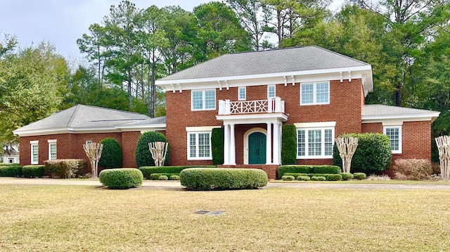 colonial house with brick siding and a front yard