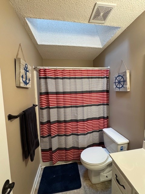 bathroom with a textured ceiling, vanity, toilet, and curtained shower