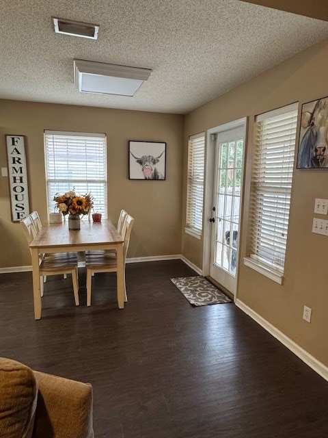 dining room with dark hardwood / wood-style floors and a textured ceiling