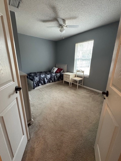 bedroom with carpet flooring, ceiling fan, and a textured ceiling