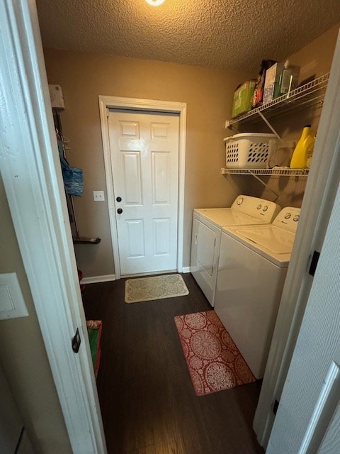 laundry room featuring a textured ceiling, dark hardwood / wood-style flooring, and separate washer and dryer