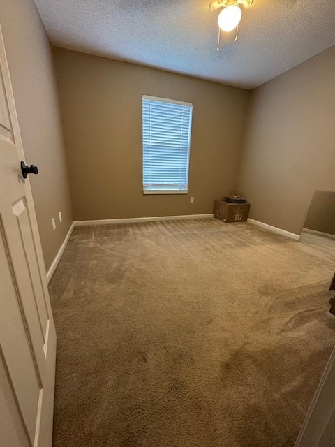 carpeted spare room featuring a textured ceiling