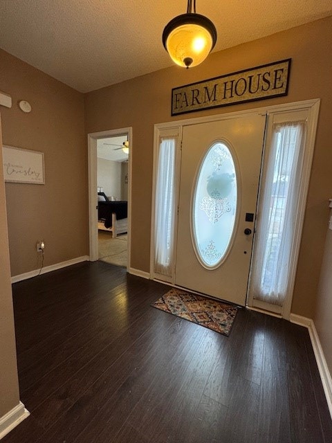 entryway featuring a textured ceiling, ceiling fan, and dark hardwood / wood-style floors