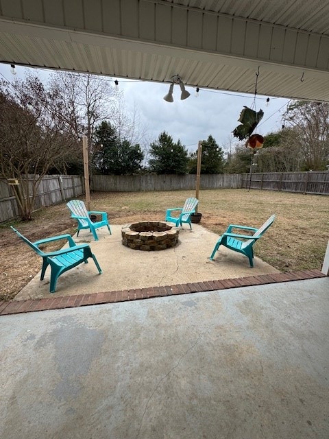 view of play area featuring a lawn, a patio area, and a fire pit