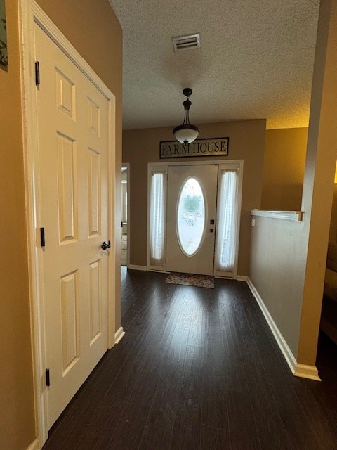 foyer with dark hardwood / wood-style flooring and a textured ceiling