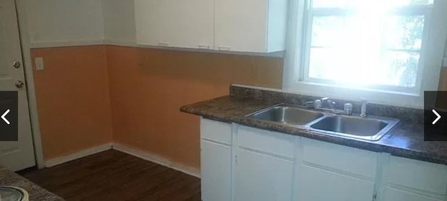 kitchen with white cabinets, sink, and dark wood-type flooring