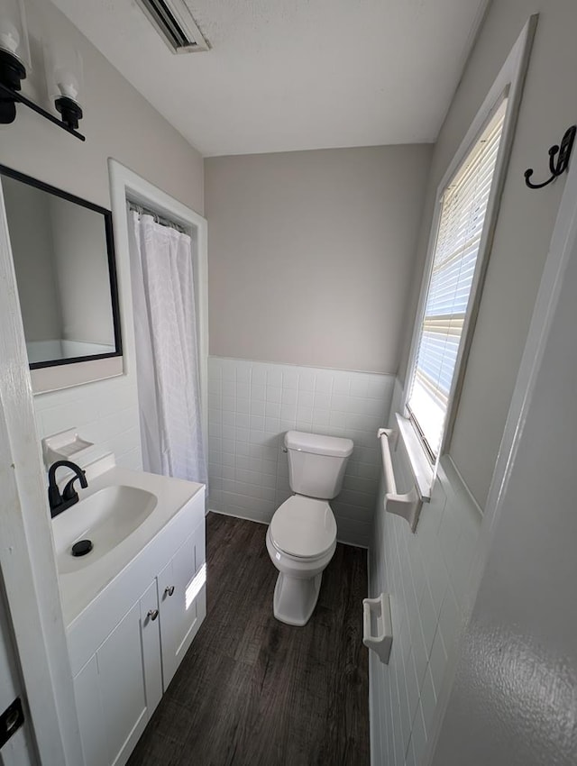 bathroom with vanity, wood-type flooring, tile walls, and toilet