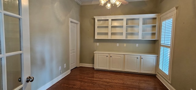 interior space featuring crown molding, baseboards, and dark wood-style flooring