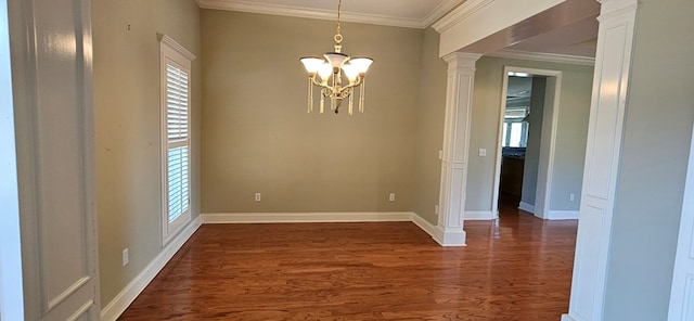 unfurnished dining area with a notable chandelier, ornamental molding, baseboards, dark wood-style flooring, and ornate columns