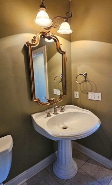 bathroom with tile patterned flooring, toilet, and baseboards