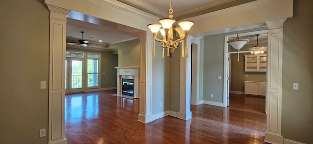 interior space with dark wood-type flooring, baseboards, decorative columns, ceiling fan with notable chandelier, and a fireplace