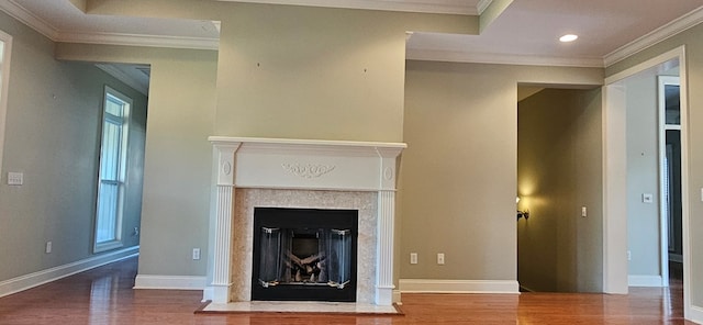 unfurnished living room with a glass covered fireplace, wood finished floors, and ornamental molding